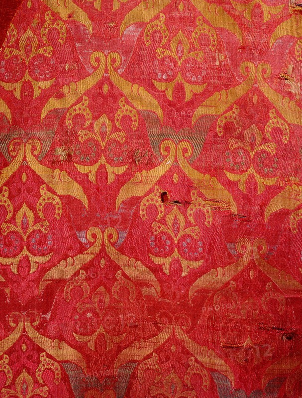 A detail of a red and gold silk weaving from Granada