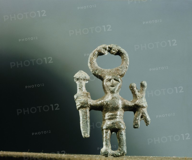 Pendant or amulet of a man holding a sword and two spears and wearing a horned helmet