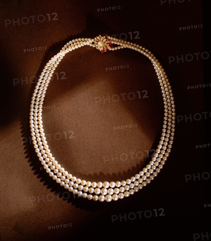 A three strand pearl necklace with gold clasp