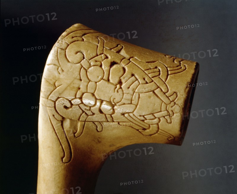 Relief carving, perhaps the handle of a walking stick