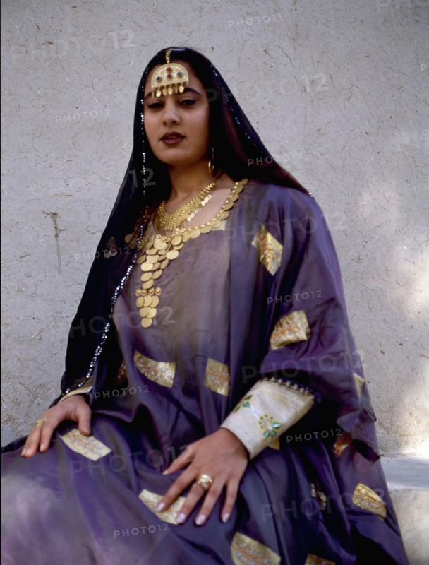 A woman wearing impressive gold jewellery and traditional costume