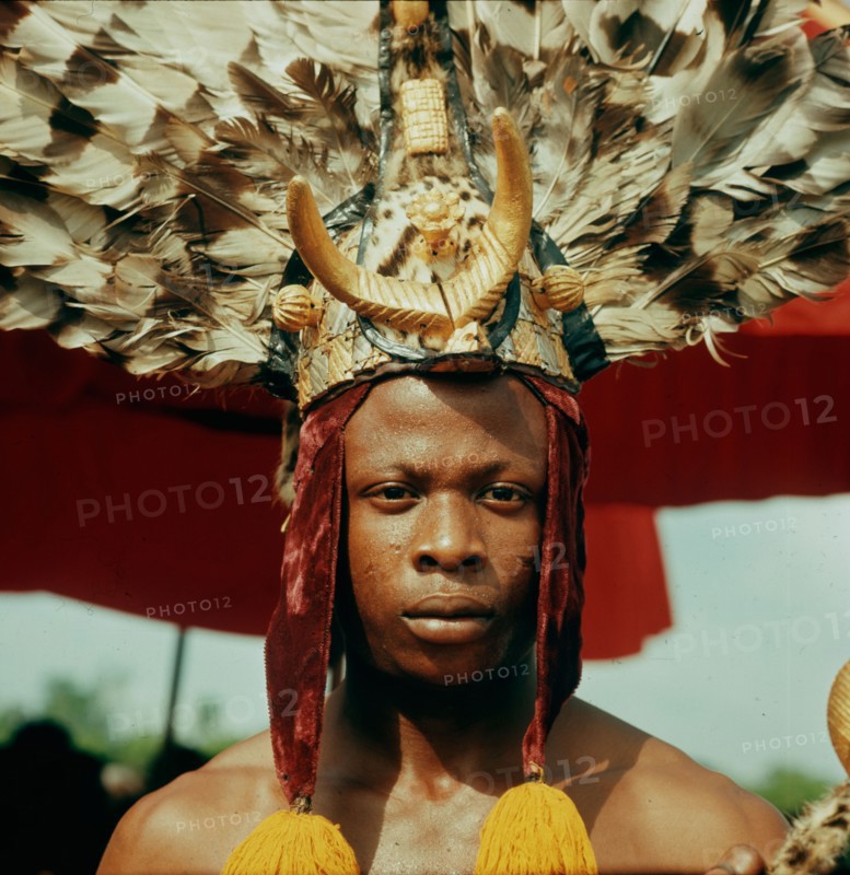 An attendant of the Omanhene of Akrokerri wearing elaborate feather headdress in the procession to celebrate the Yam Festival