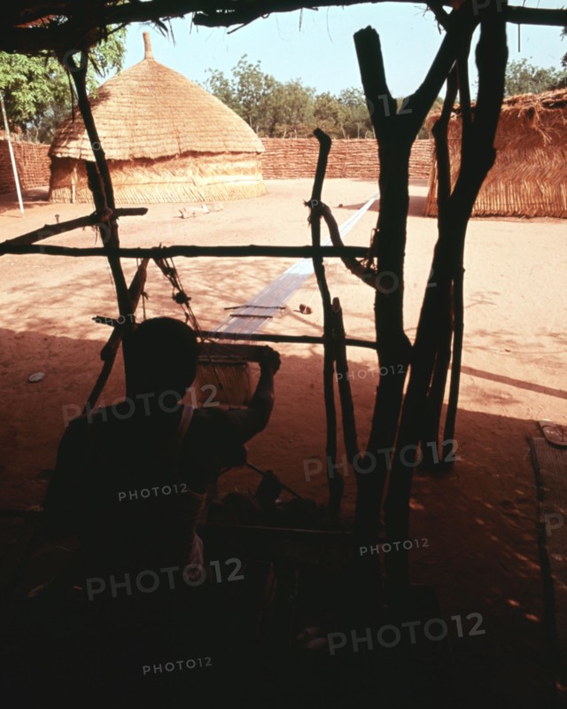 Weaving on the horizontal double heddle loom typical of West Africa