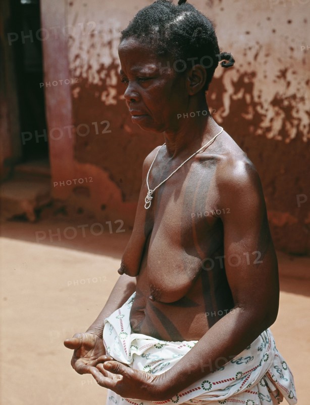 The wife of a Benin chief displays her body decorations