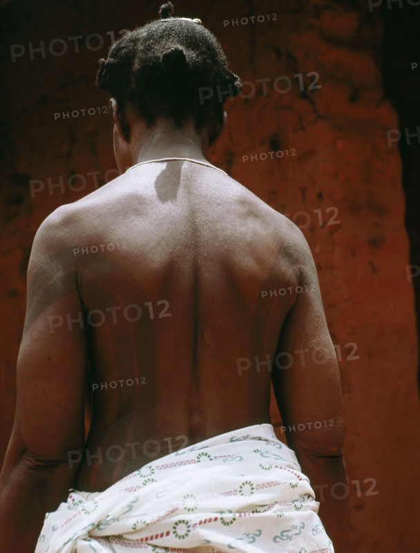 The wife of a Benin chief displays her body decorations