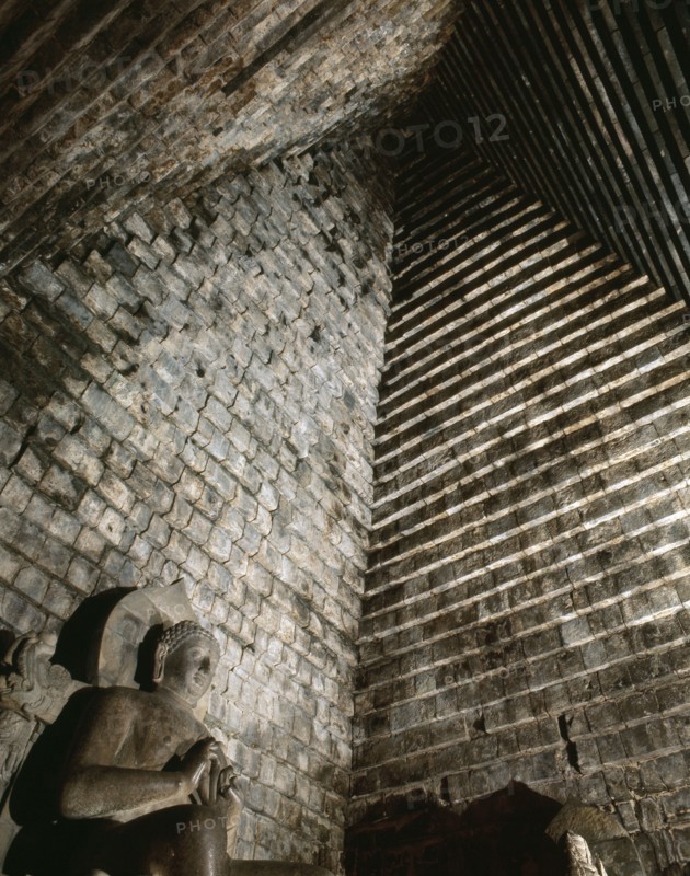 A statue of the seated Buddha in Chandi Mendut, one of the several temples associated with Borobudur