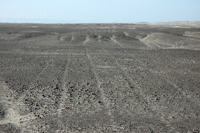 Parallel Nazca lines converging on / radiating out of a small hill