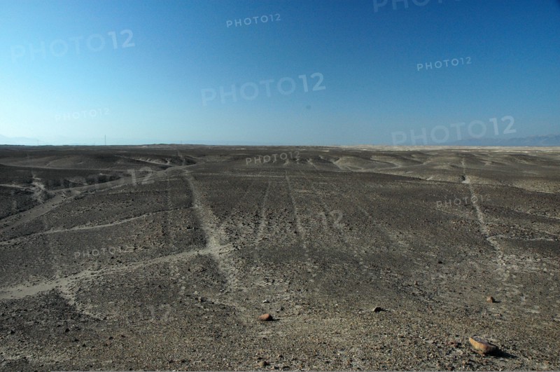 Nazca lines of varying widths converging on / radiating out of a small hill