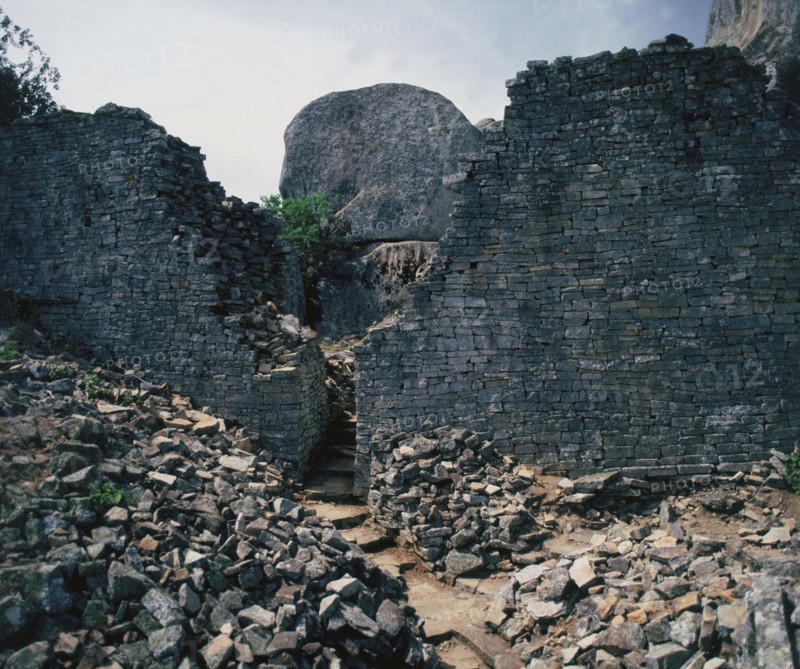 View of a stone pathway between partially restored walls from the site of great Zimbabwe