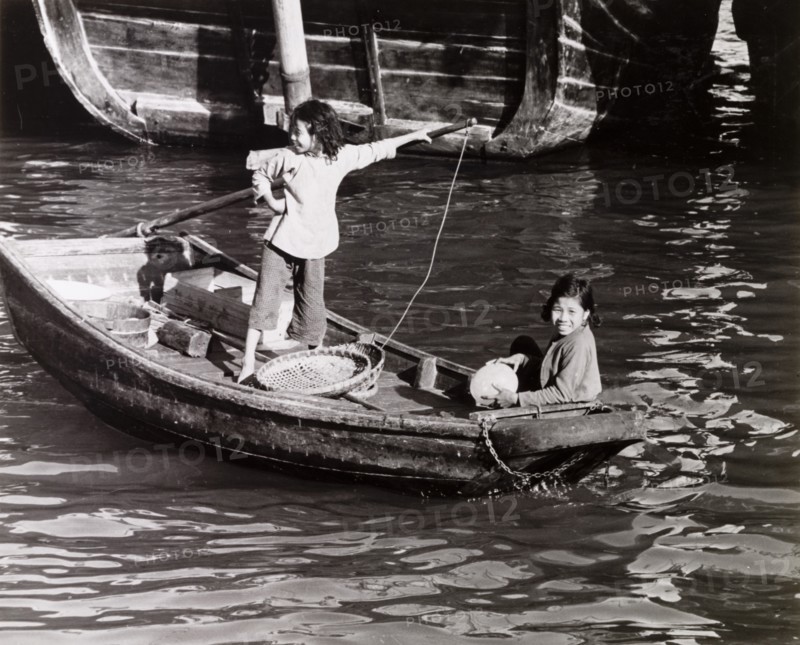 Chinese girls steer a sampan