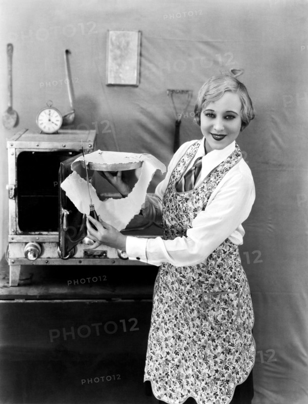 United States:  c. 1923.
A woman trims the excess crust off a pie before baking.