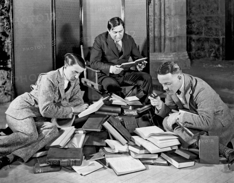 Three Men Searching Books