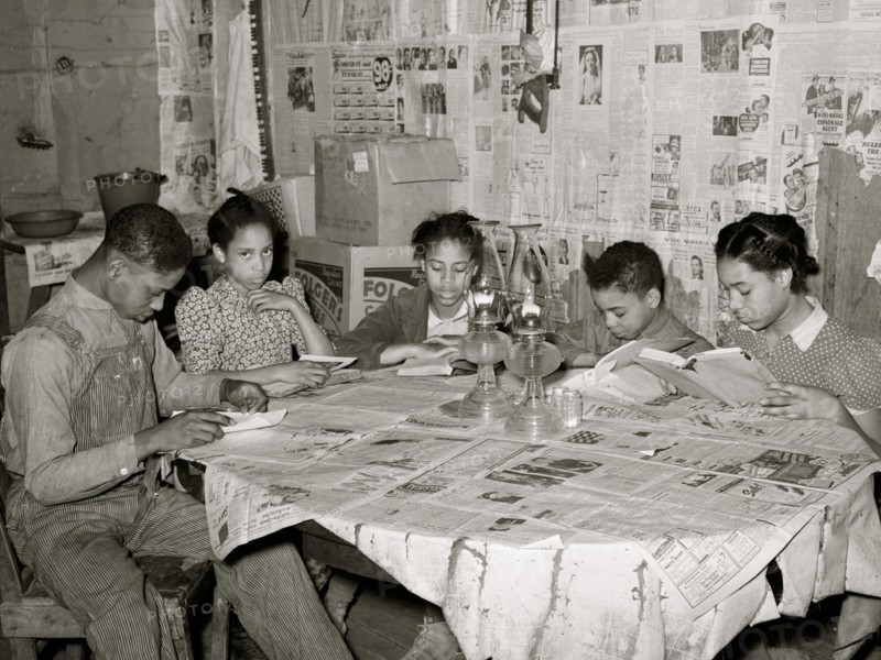 Five children of Pomp Hall, Black tenant farmer, studying their lessons by lamplight. Creek County, Oklahoma. 1938