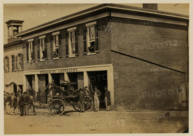 Union soldiers pull a fire engine from a garage designated Petersburg artillery 1865