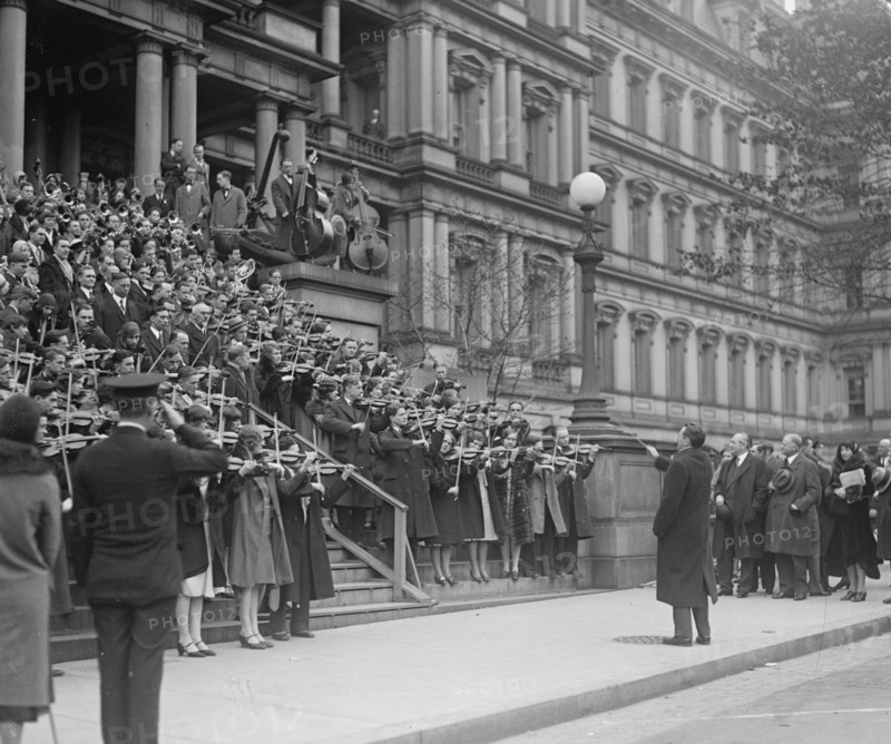 A hundred Massed Violins on the Steps of the Navy Building in Washington, DC play the Star Spangled Banner to the saluting of officials 1917