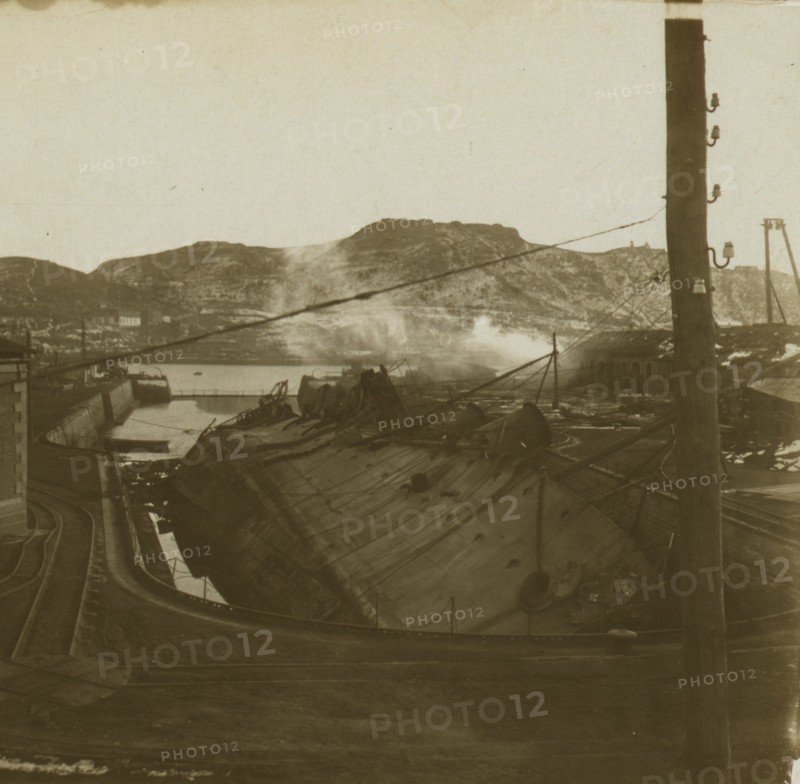 A warship on its side at a quay, Port Arthur 1905
