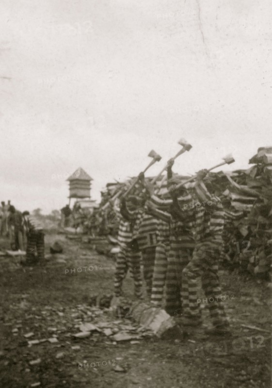 African American convicts working with axes, watchtower in background, Reed Camp, South Carolina 1934