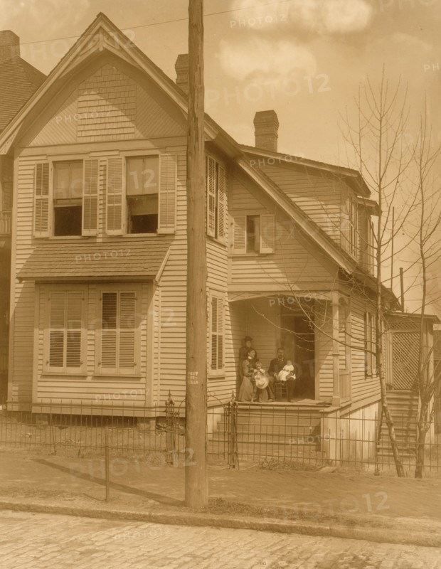 African American family posed on porch of house 1899