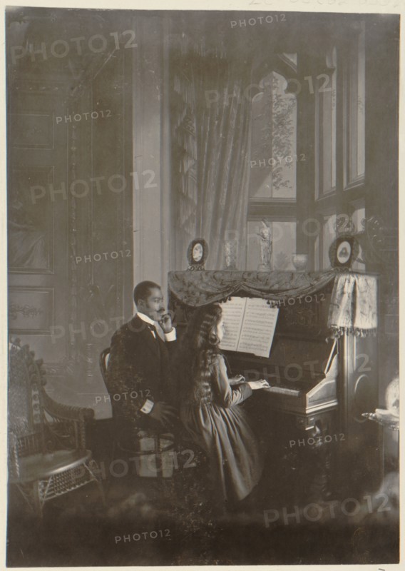 African American man giving piano lesson to young African American woman 1899