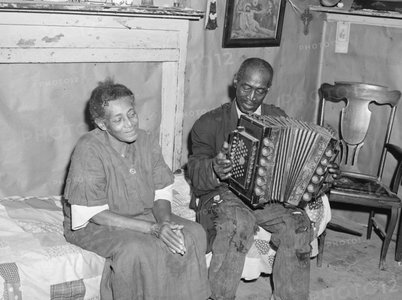 African American Mr. Dyson, aged FSA  borrower plays the accordion.  1940