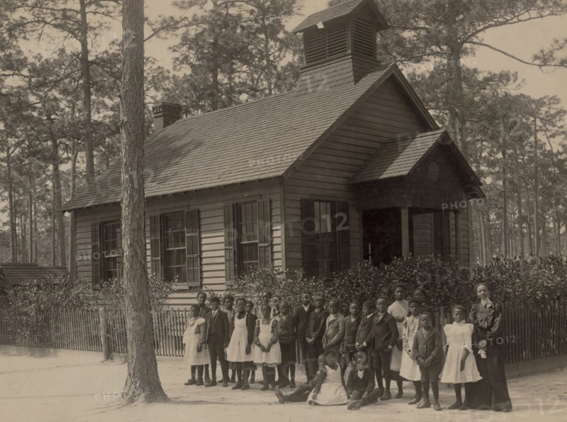 African American school children posed with their teacher outside a school, possibly in South Carolina 1905