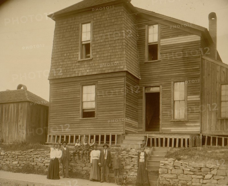 African Americans standing on sidewalk in front of house in Georgia 1899