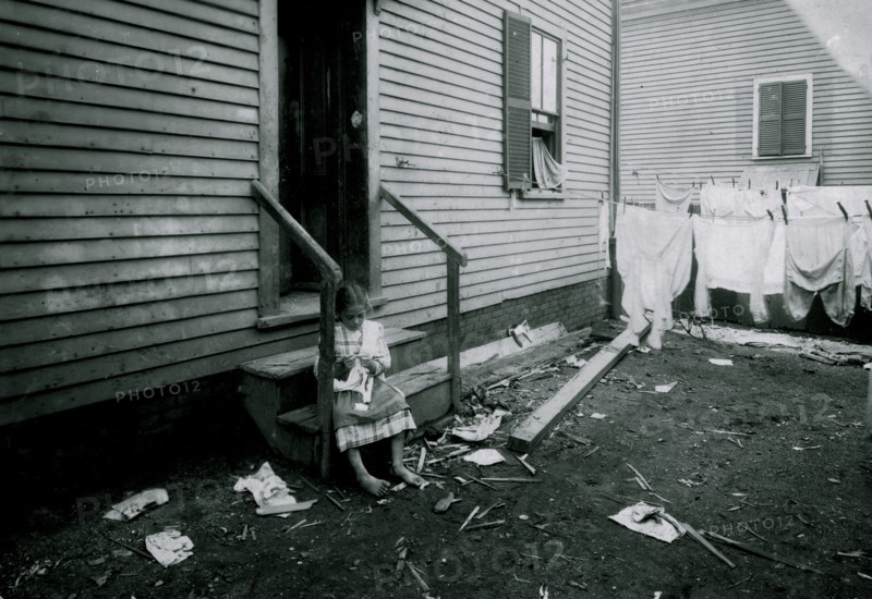Annie Fedele crocheting on underwear out in the filthy back yard. This is one of the places she works on crochet 1912