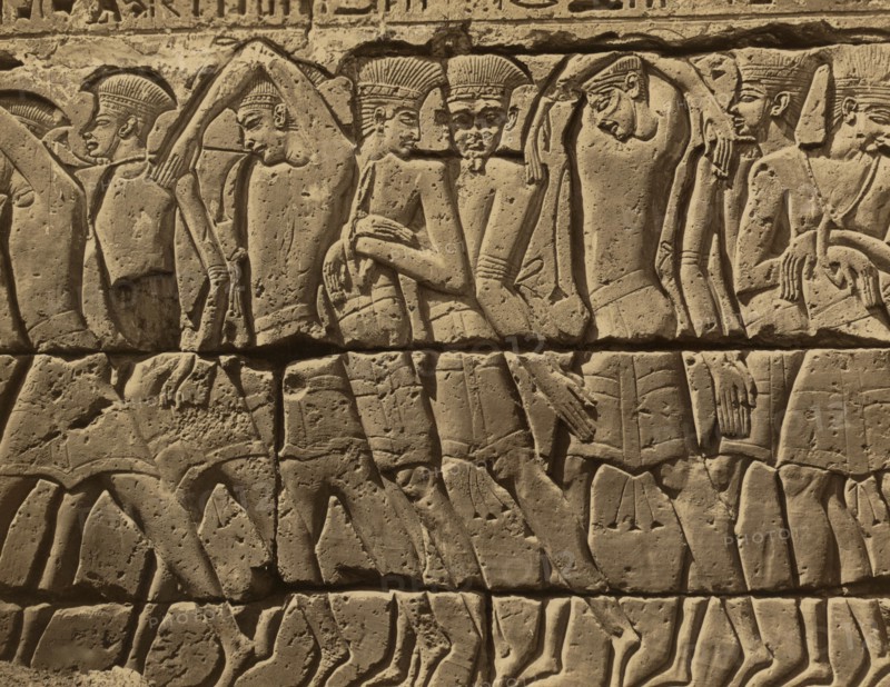 Bas-relief of several men, standing, left of the door of the Great Temple at Medinet-Abou 1880