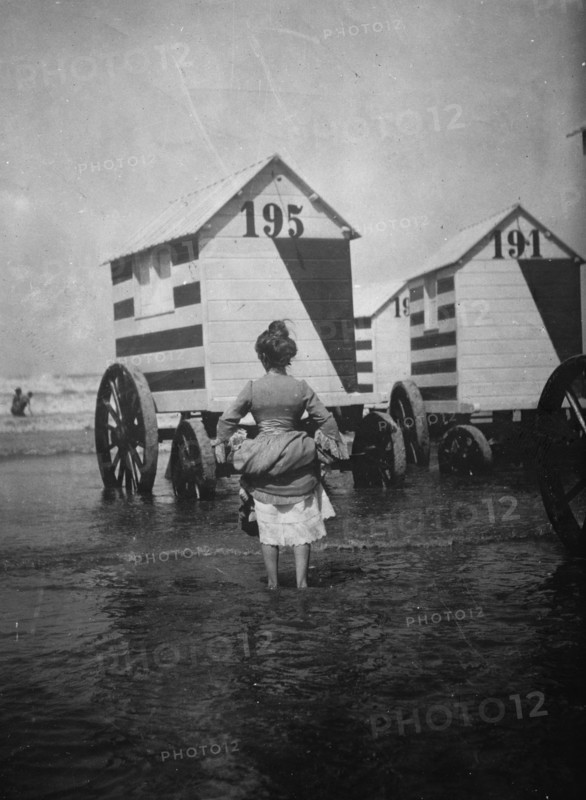 Bathing Booths at Ostend, Belgium; womanbather lifts up her dress 1912