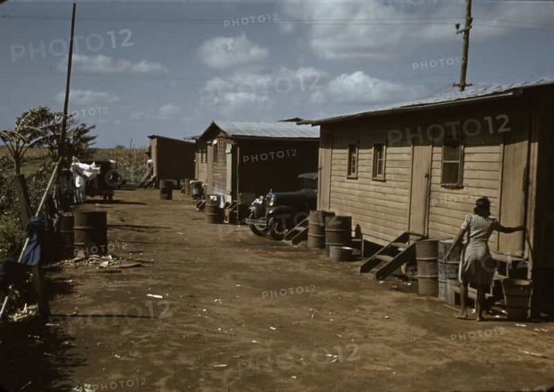 Black migratory workers by a shack, Belle Glade,  1941
