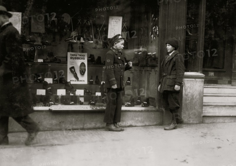 Boston delivery by in front of a retail shop speaks to a friend 1917