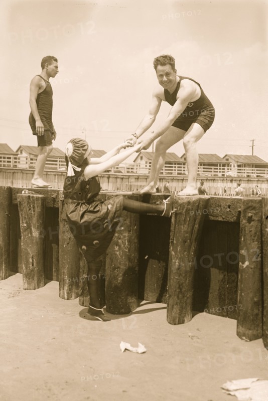Boy Lifts Girl from the beach bulkhead