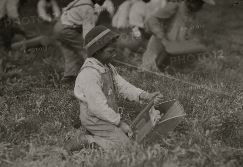 Charlie Fernande showing the scoop with which he works. Most of the scooping is done by adults. 1911