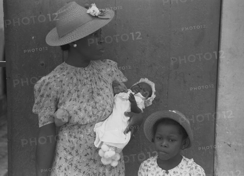 Mother and children waiting on the main street on Sunday 1941