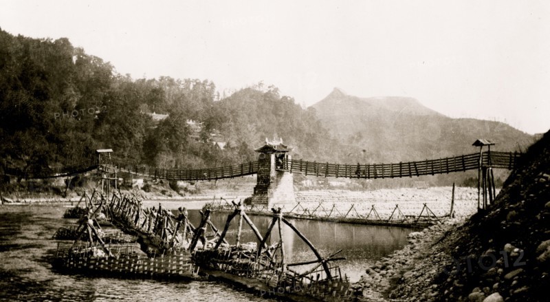 Chinese built suspension bridge, boats docked at pier in foreground, Szechwan Province, China