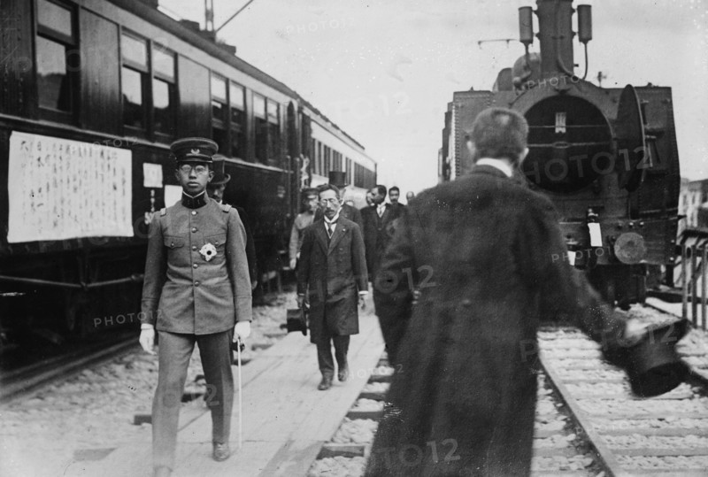 Crown Prince, in uniform walks beside a train at station