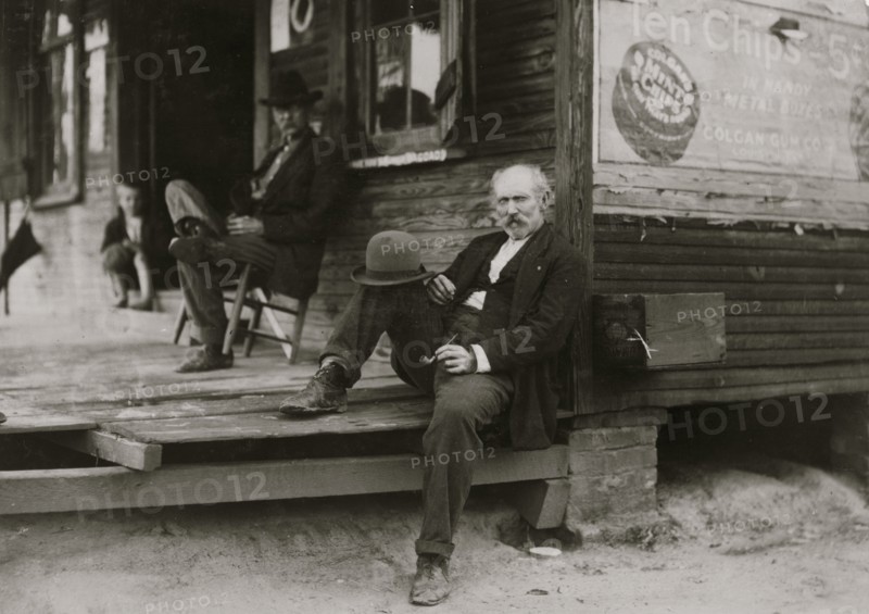 Dependent Widower sits on steps; the children work to support him 1911
