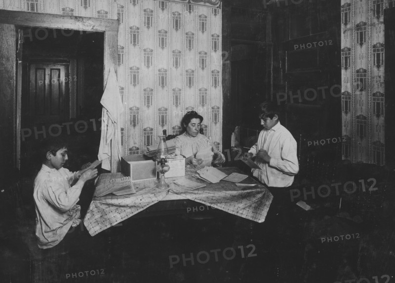 Family of David H. Goodman,. Mother and two children,  working on tags for Dennison factory. 1912