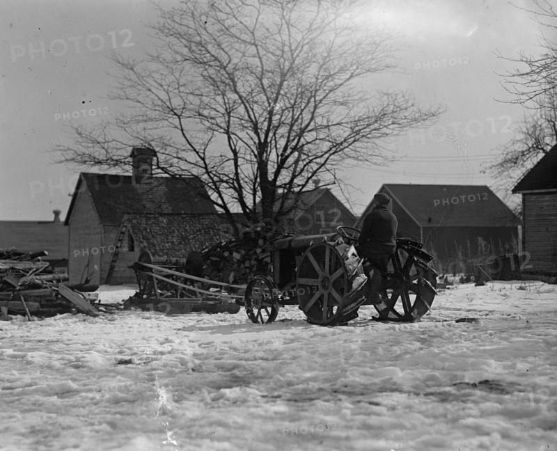 Farmer Drives Ford Tractor in yard 1924