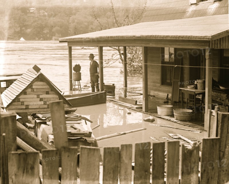 Flood with people looking out over a rover overflowing its banks 1924