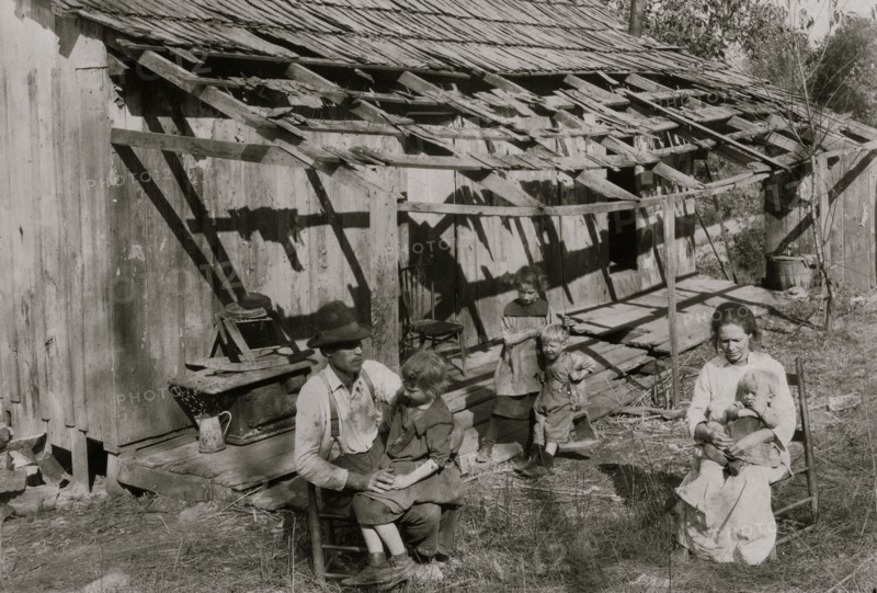 Frank Burditt and family. They rent this dilapidated shack and are trying to make a living off the meager land near by.  1921