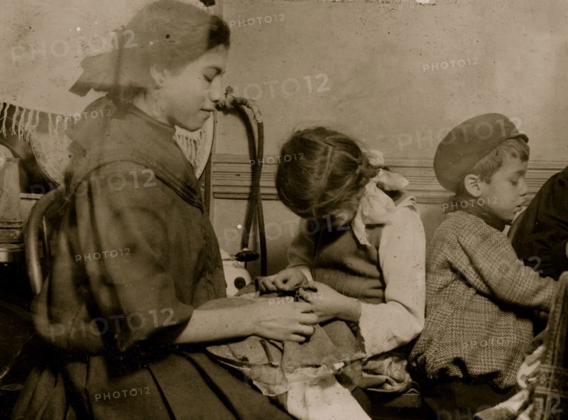 Italian Family works on garments in their tenement apartment 1911