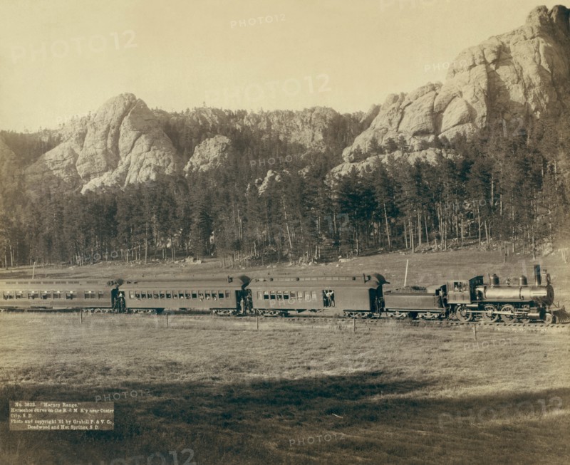 Full view of as train coming through the mountains in the West 1891