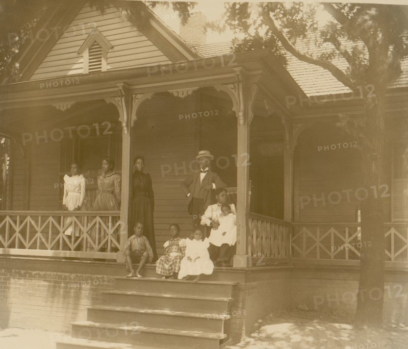 Home of an African American lawyer, Atlanta, Georgia, with men, women, and children posed on porch of house 1899