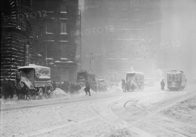 Horse-drawn wagons on snowy street, NY snow storm 1910