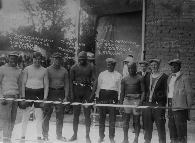 Jack Johnson & trainer in camp- Marty Cutle, W. Burns, C. Respress, Jack Skully, J. DeBray, Perkins 1912