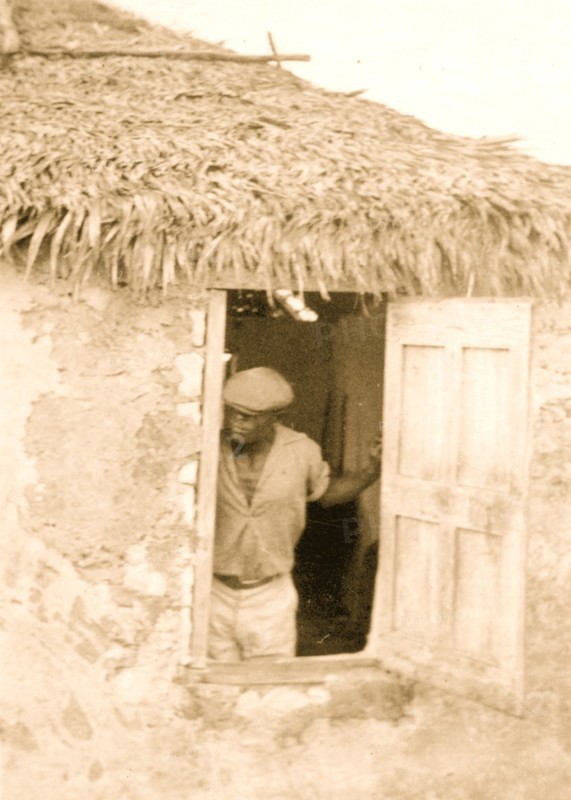 Man standing at door of house, looking out, possibly from the visit by Alan Lomax and Mary Elizabeth Barnacle to Cat Island in the Bahamas 1935