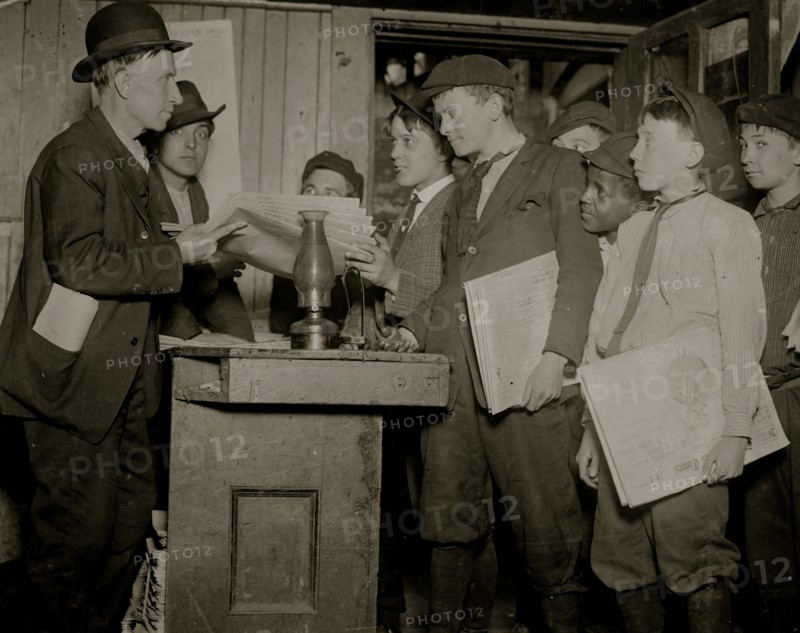 Newsboys pick up their papers and settle up in a basement Branch or office for newspaper sales 1910