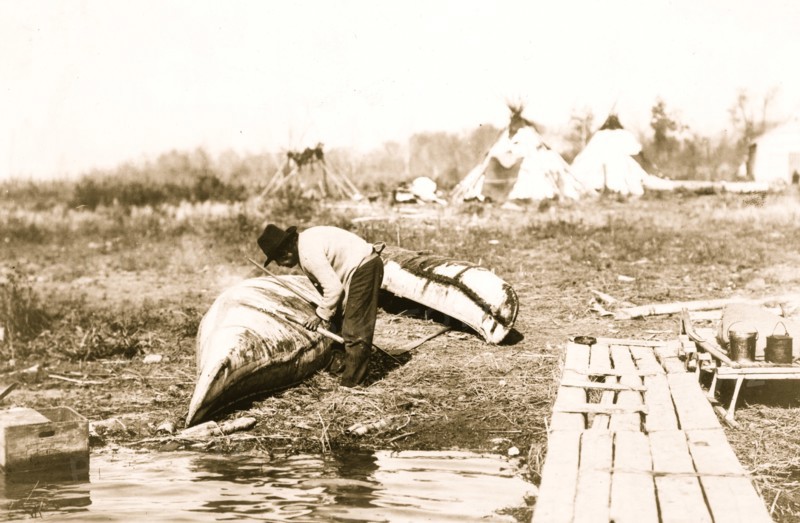 Mending his canoe 1913