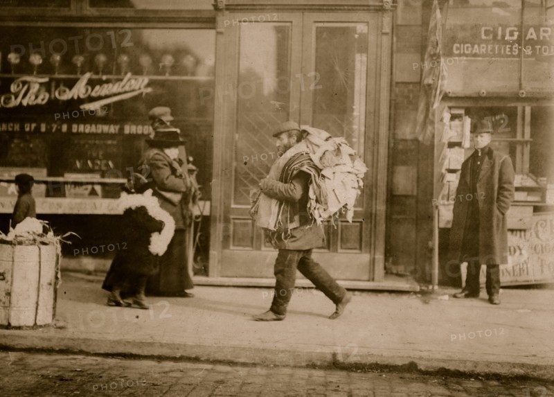 Old man carrying garments, Delancey St., N.Y 1912